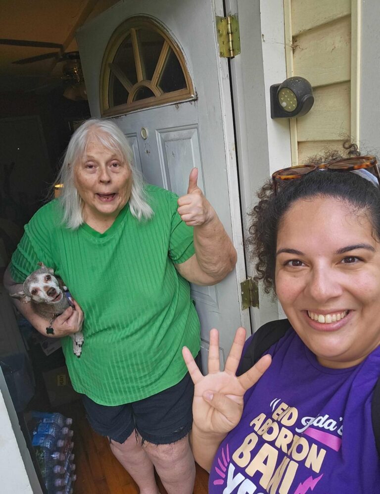 A volunteer knocks on a neighbor's door who is in support and gives a thumbs up for Amendment 4. Her dog is vocally in support as well.